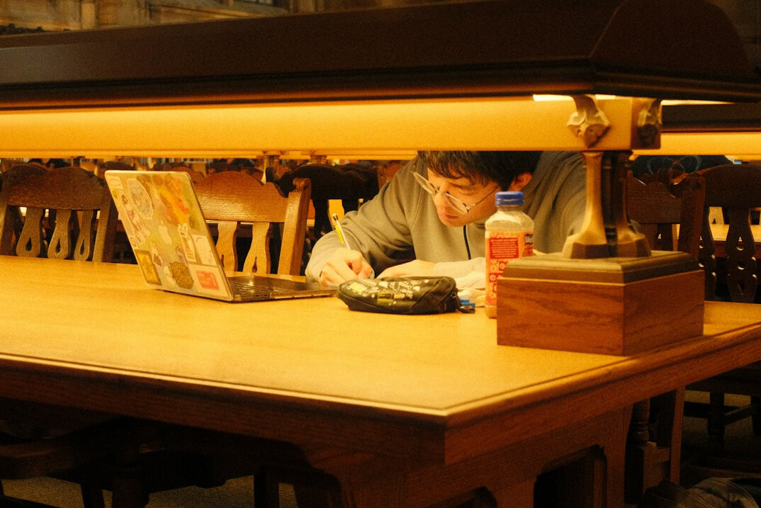 writer working on laptop in library